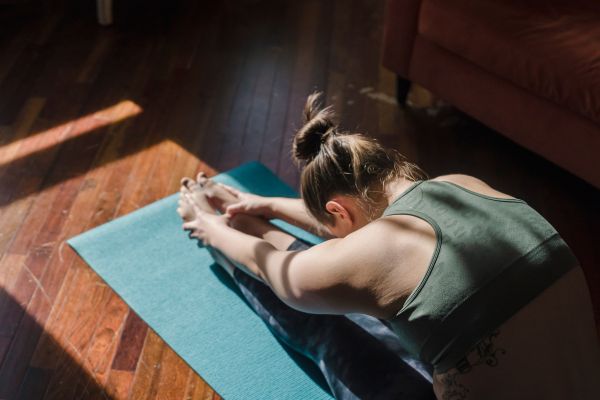 mujer practicando yoga en el suelo para complementar el plan detox ayurveda